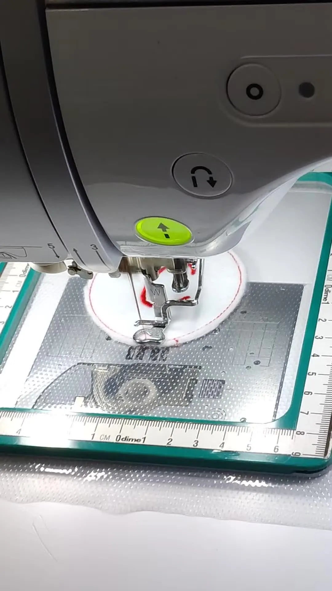 A close-up of the embroidery machine stitching a dense satin border that seals the patch edge.
