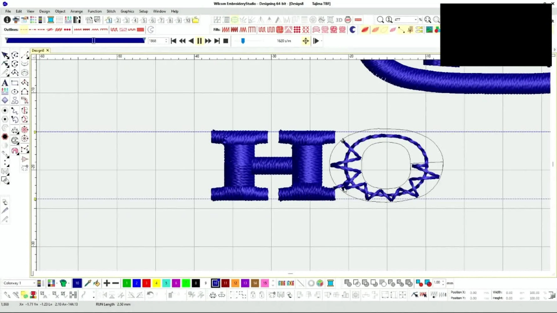 A finished navy Honda logo stitched cleanly on white polo fabric, photographed overhead on a cutting mat.