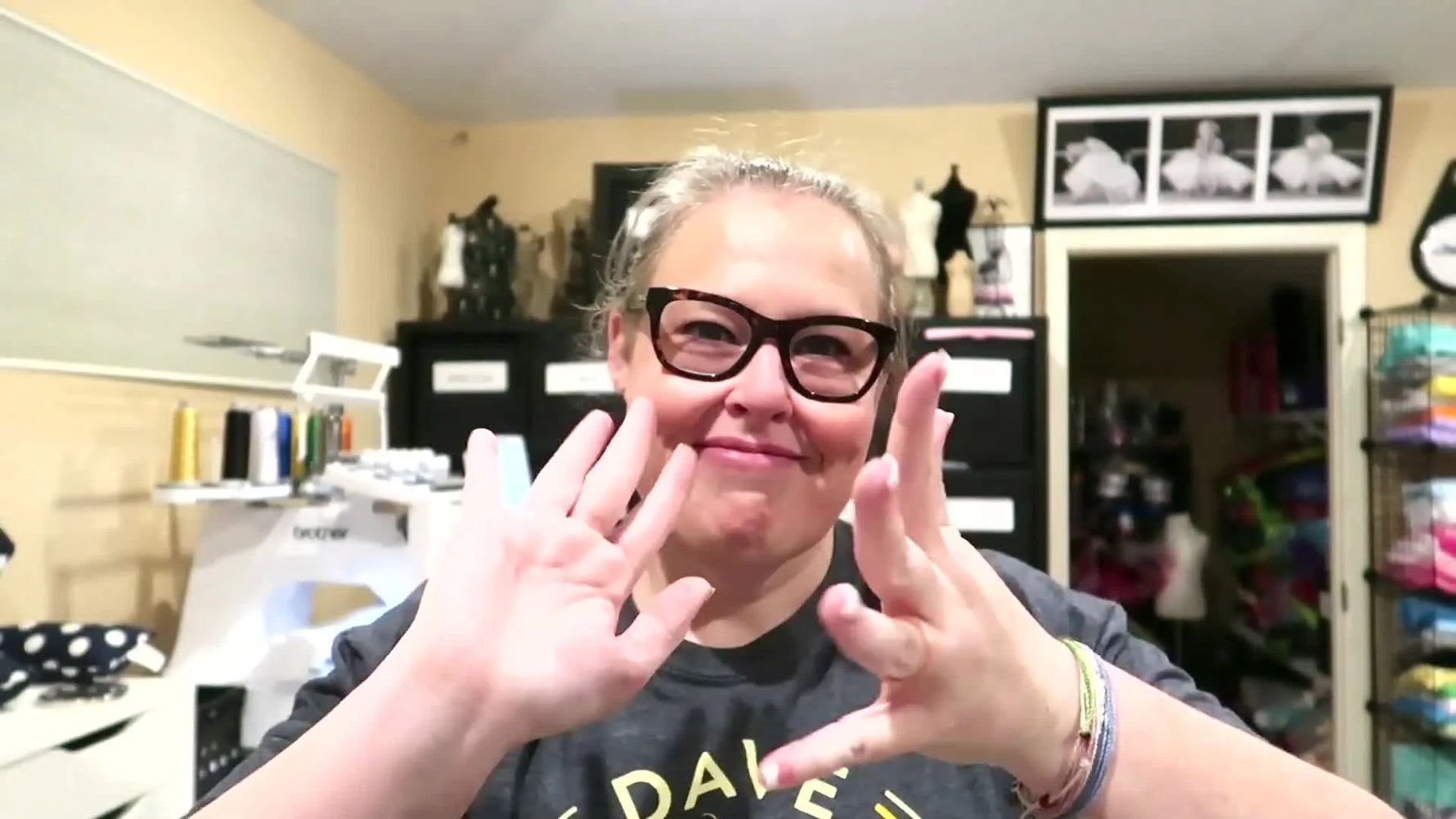 Creator smiling at camera, showing both hands with fingers splayed.