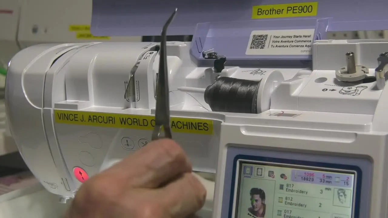 A Brother PE900 actively stitching a dense Elvis photo stitch portrait while the LCD shows the design preview and progress.