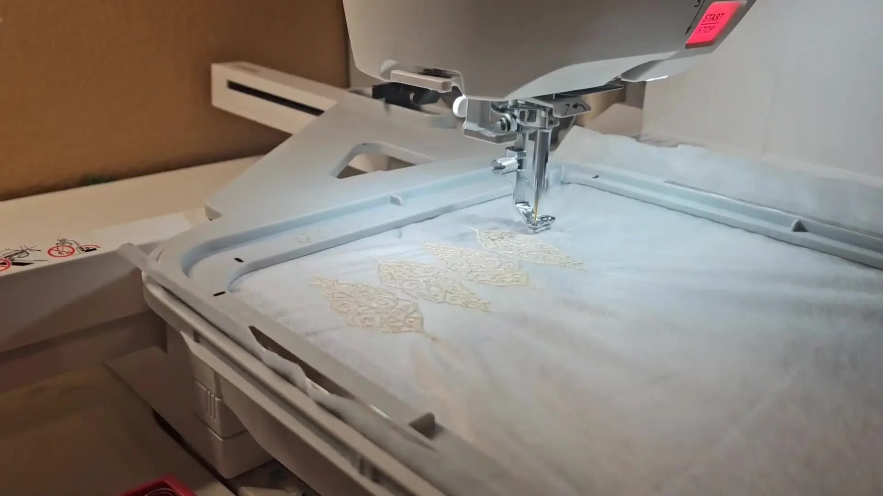 Multiple freestanding lace leaves are being stitched in a neat row on water-soluble stabilizer inside a Janome hoop.