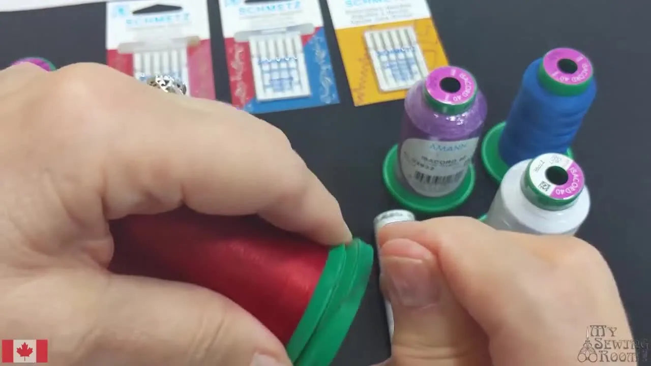 Hands demonstrate the snap-base feature on an Isacord spool to lock down a loose thread tail for clean storage.